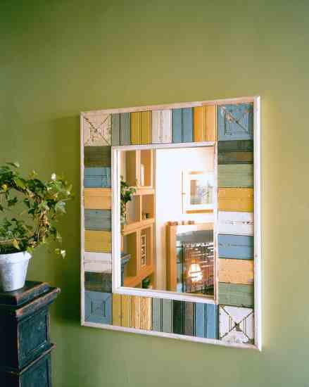 The hallway mirror is framed with pieces of painted wood salvaged from Southern barns.